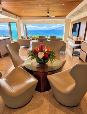 A modern interior with a round glass table, leather chairs, a wooden ceiling, and a view of the ocean. - Stunning Ocean view -Wailea Point 2bd/2b Condo (Wailea)