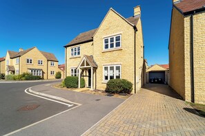 A residential street with houses featuring stone facades and pitched roofs. - Modern Home Near Blenheim Palace & The Cotswolds - Pass the Keys (Long Hanborough)