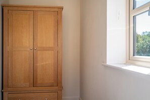 A wooden wardrobe with two doors and a lower cabinet with drawers. - Modern Home Near Blenheim Palace & The Cotswolds - Pass the Keys (Long Hanborough)