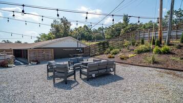An outdoor seating area with a gravel ground, a covered structure, and a wooden fence.