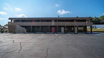 A building with a red door, a parking lot, and a flag.