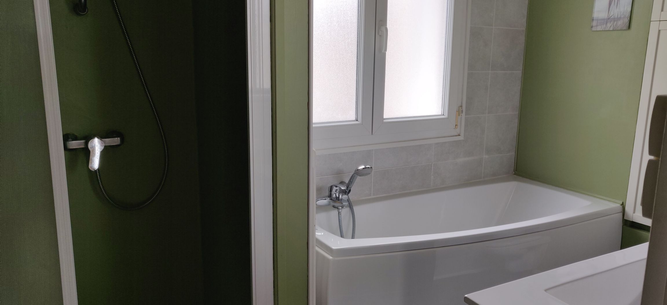Un baño con bañera, ducha y ventana.