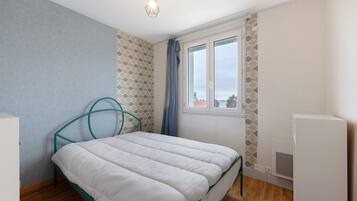 Un dormitorio con cama, ventana y radiador.