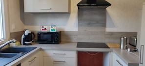 Une cuisine compacte équipée d’un four à micro-ondes, d’une machine à café et d’un grille-pain.