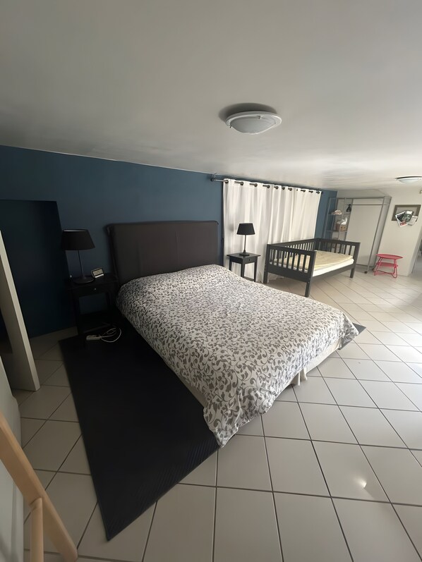 Ein Schlafzimmer mit Bett, Nachttischen, einem Schreibtisch und einem Stuhl.