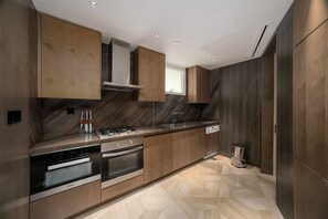 Een moderne keuken met inbouwapparatuur, houten keukenkastjes en een visgraatvloer.