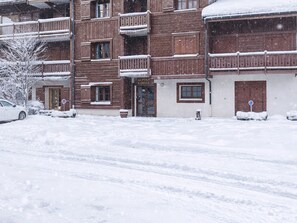 A multi-story wooden building with balconies, a visible entrance, and a sign that reads 'Alpine Lodge.' - 3-room apartment at the foot of slopes, terrace, 6 pers (Les Deux Alpes)