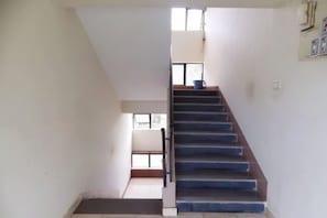 Una escalera conduce a un piso superior con vistas al exterior.