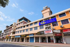 Un edificio de varios pisos con diversos comercios, incluyendo una licorería, un restaurante familiar y un hotel.