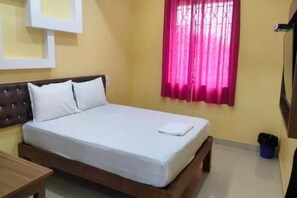 A single-bed room with a wooden headboard, a bedside table, and a window with pink curtains.