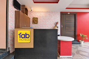 Una recepción con un letrero de 'fab hotels', una cámara de seguridad y un extintor en la pared.