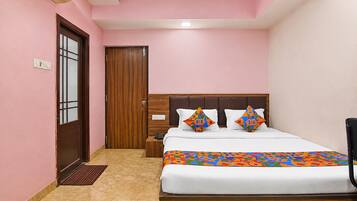 Un dormitorio con una cama, una mesita de noche, una puerta de madera y un aire acondicionado instalado en la pared.