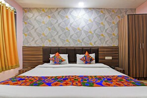 Una habitación de hotel con cama, cabecera, armario y pared con diseño.