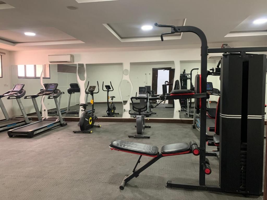 A gym with treadmills, a bench press, and weight machines.