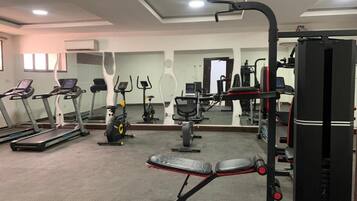 A gym with treadmills, a bench press, and weight machines.