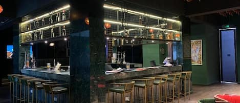 A bar area with a counter, stools, and a seating area with chairs.