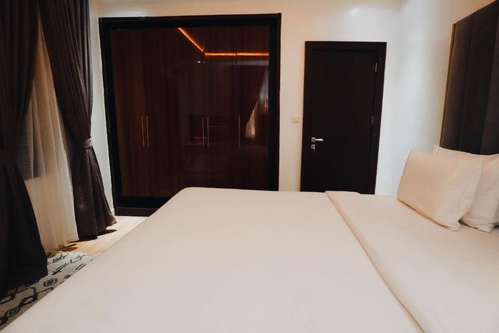 Una habitación de hotel con cama, armario y puerta.