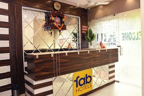 Una recepción con un letrero de 'fab hotels', un reloj y una guirnalda decorativa.