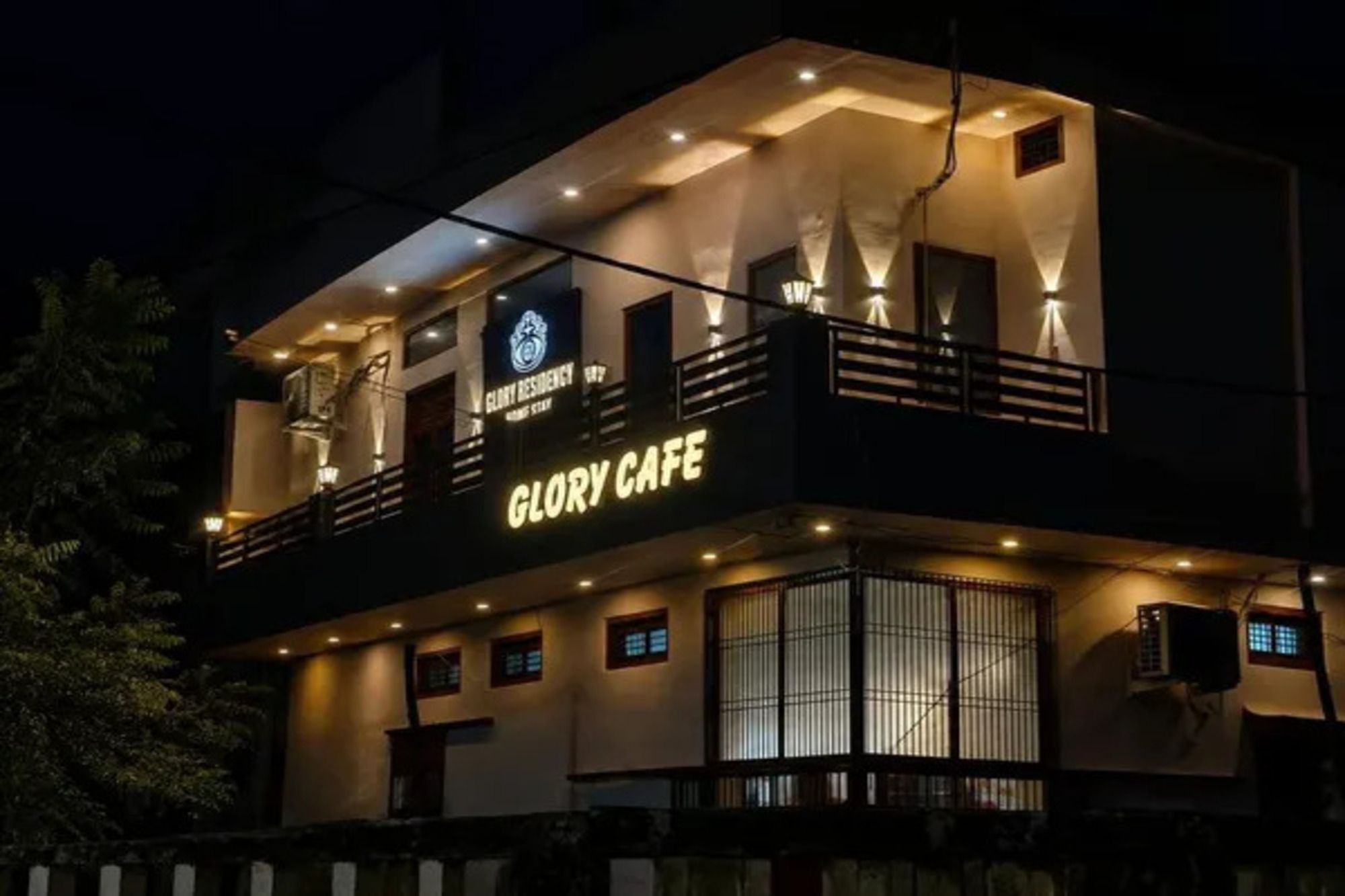 A two-story building with a balcony and a sign reading 'GLORY CAFE'.