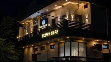 A two-story building with a balcony and a sign reading 'GLORY CAFE'.