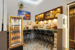 Zona de bar con refrigerador, taburetes, un tocadiscos antiguo y un rebozado de azulejos.