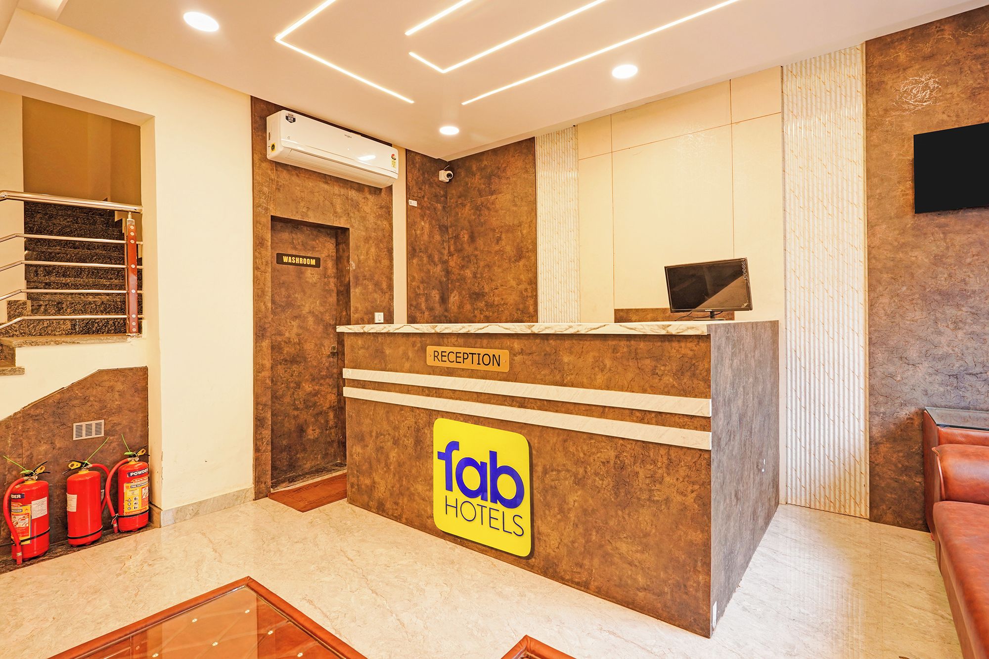 Zona de recepción de un hotel con mostrador, cartelera indicativa y monitor de información.