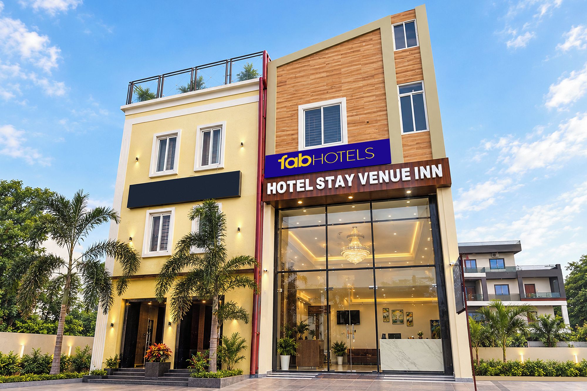 Un moderno edificio de hotel con un cartel llamativo que dice 'fabHOTELS HOTEL STAY VENUE INN'.