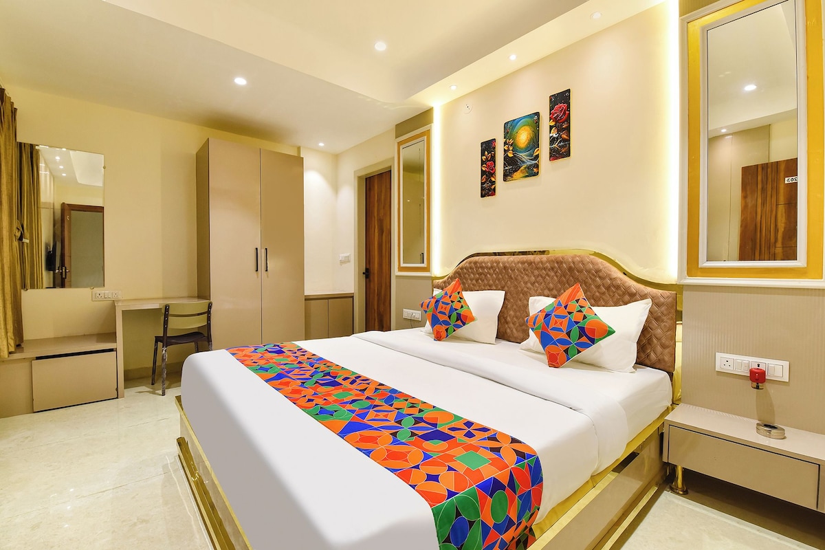 Una habitación de hotel con cama, mesita de noche y espejo.