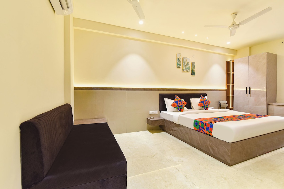 Una habitación de hotel con cama, mesita de noche, armario y un banco.