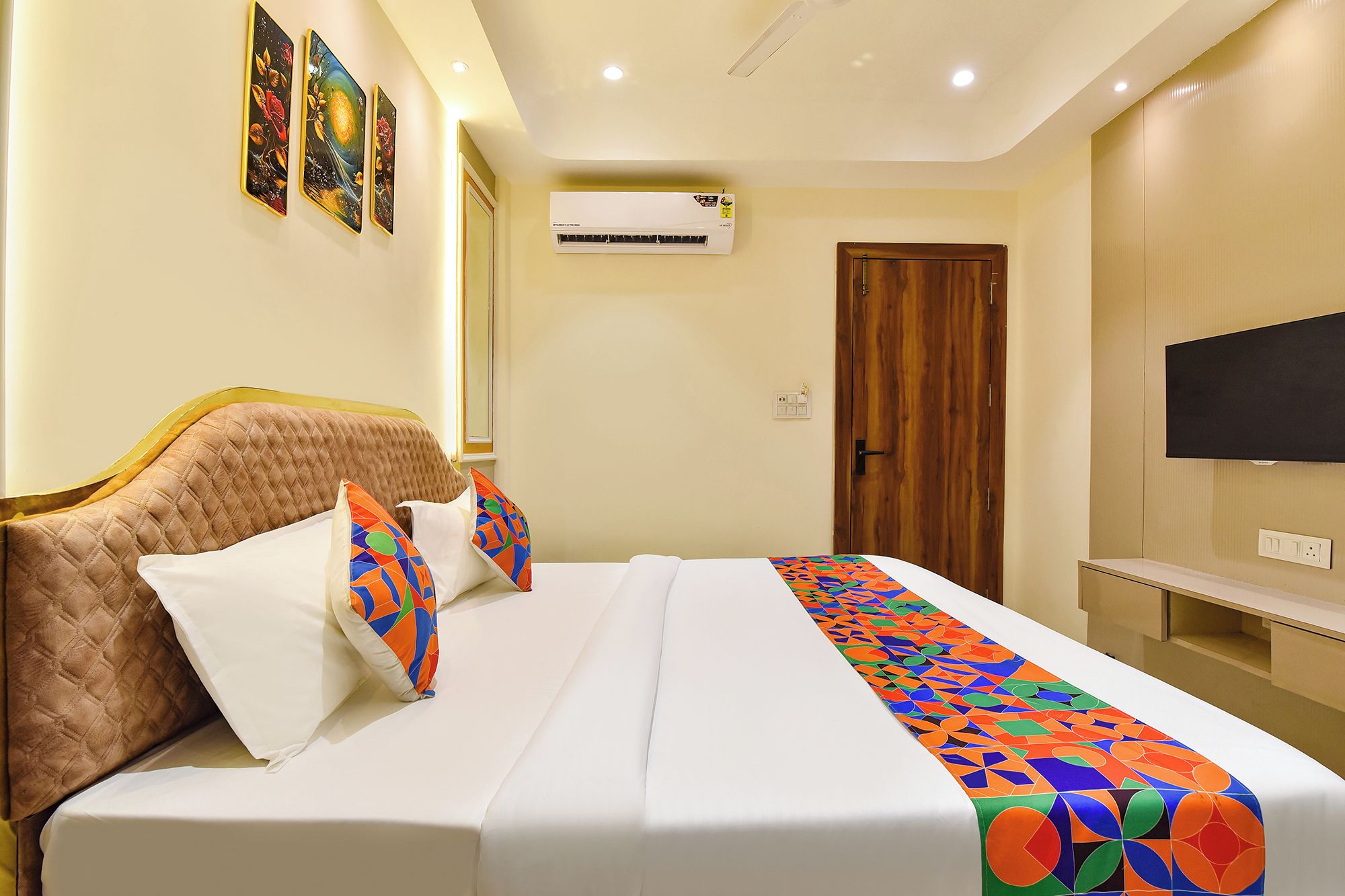 Una habitación de hotel con una cama, un televisor y un equipo de aire acondicionado.