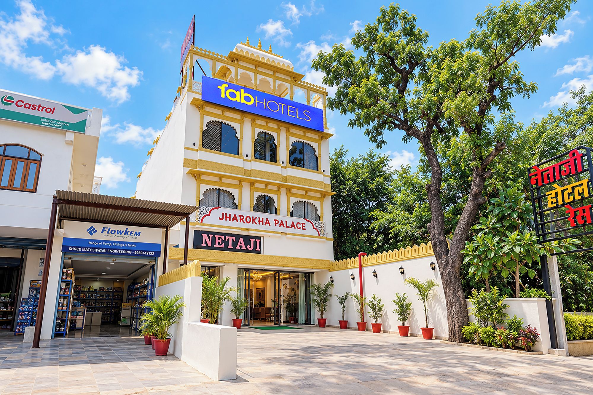 A hotel with a sign for 'Jharokha Palace' and 'Netaji' written in both English and Hindi.