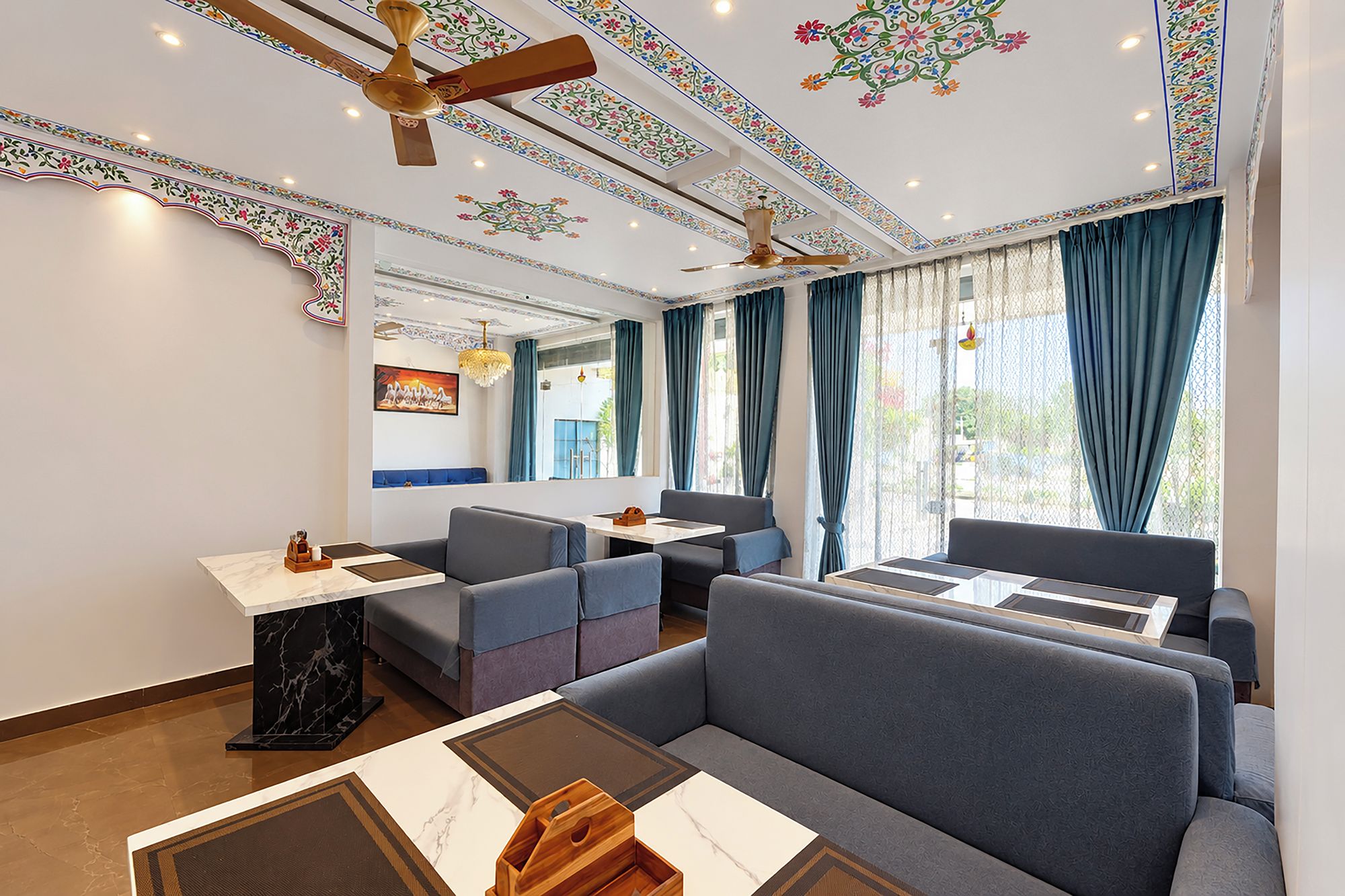 Ein modernes Hotelzimmer mit einer Sitzecke, einem Esstisch und einem Deckenventilator.