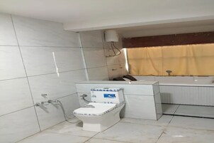 Un baño con inodoro, ducha y bañera.