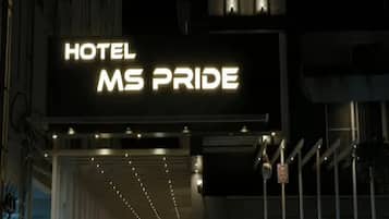 Segnaletica luminosa di un hotel con il nome 'MS PRIDE' illuminato in bianco.