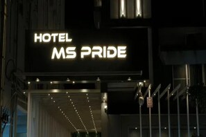 Un letrero de hotel con el nombre 'MS PRIDE' iluminado en blanco.