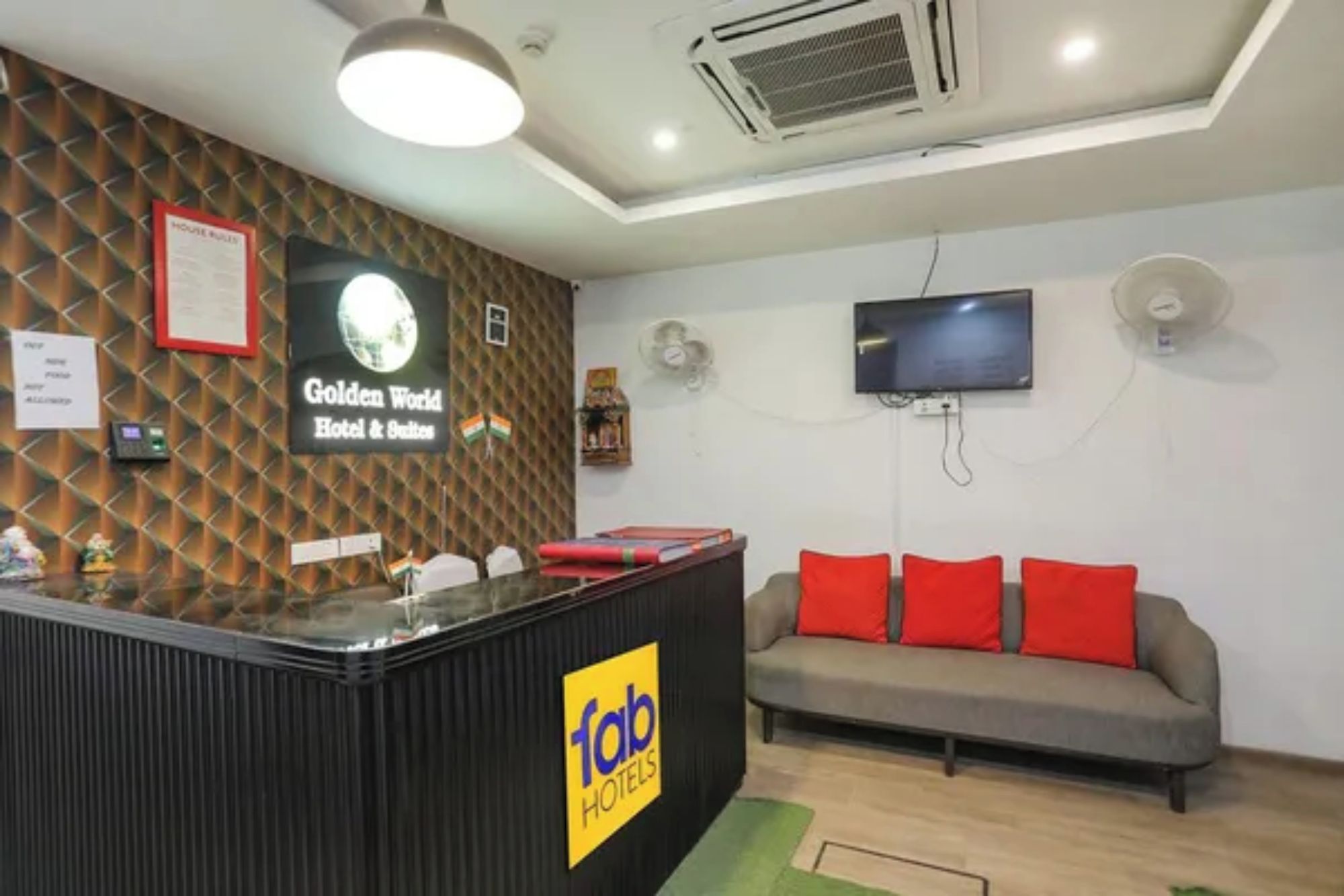 A reception area with a counter, a sofa, and a television.