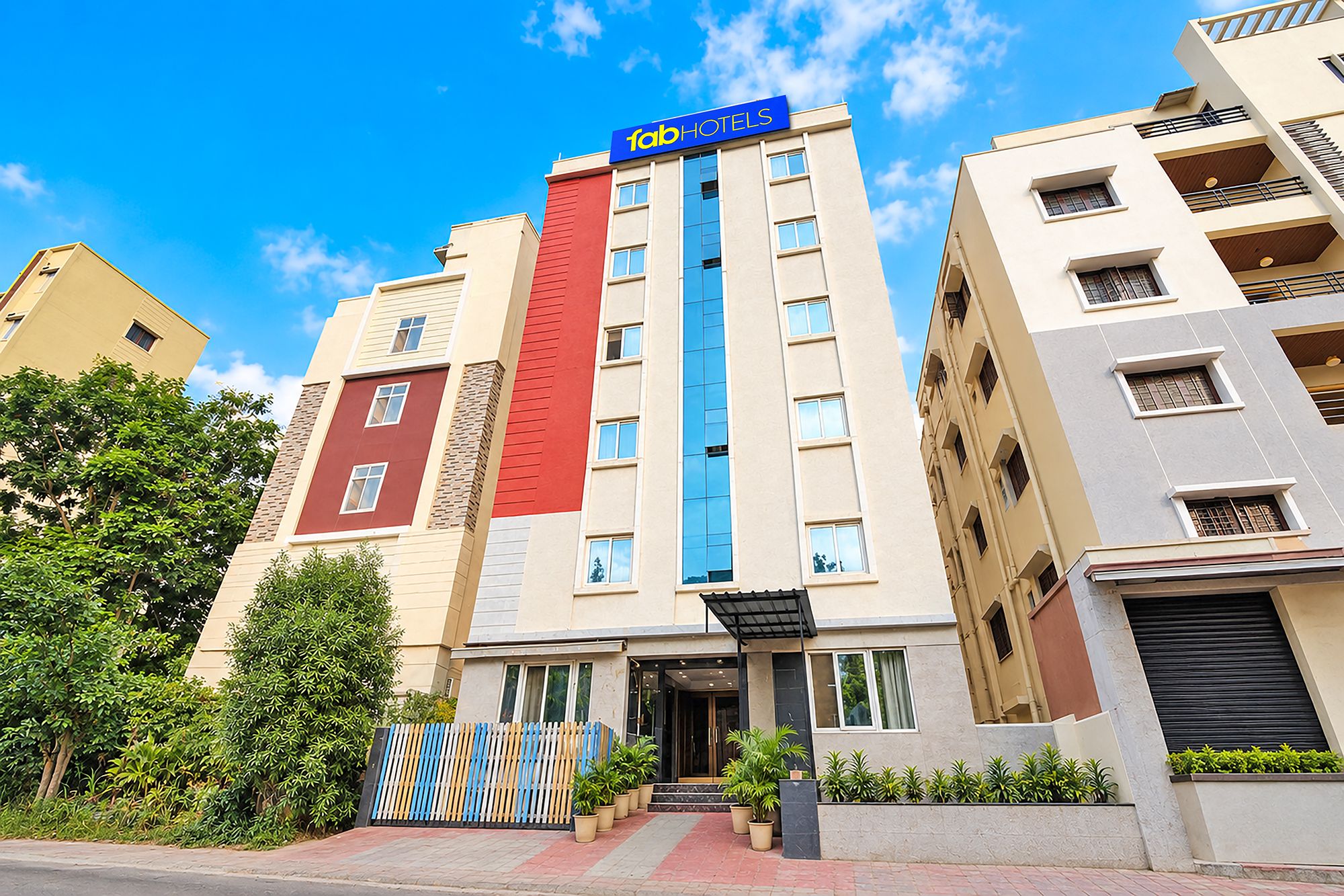 A multi-story hotel with a prominent 'fabHOTELS' sign, a modern facade, and a gated entrance.