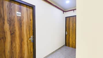 A hallway with two wooden doors, one marked with the number 405, and a tiled floor.