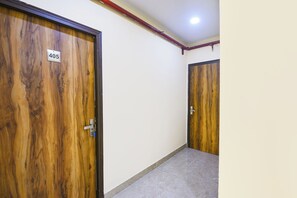 Un pasillo con dos puertas de madera, una de las cuales lleva el número 405, y un piso de baldosas.