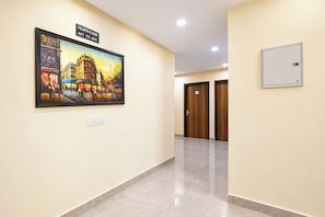 Un pasillo con un cuadro, un letrero que indica el cuarto piso y una puerta con una placa numérica.