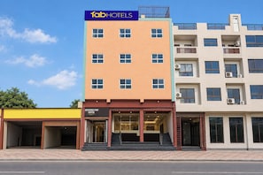 A multi-story building with a sign for 'FabHotels' on the top.