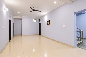 A hallway with a ceiling fan, recessed lighting, a door, and a staircase.