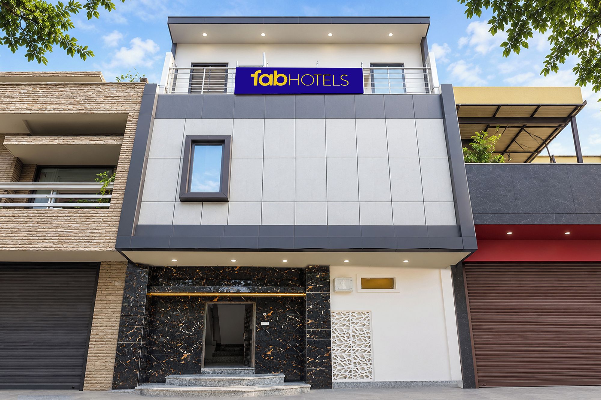 A modern building with a sign reading 'fabHOTELS' above the entrance.