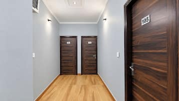 Un couloir avec deux portes en bois, chacune portant un numéro.