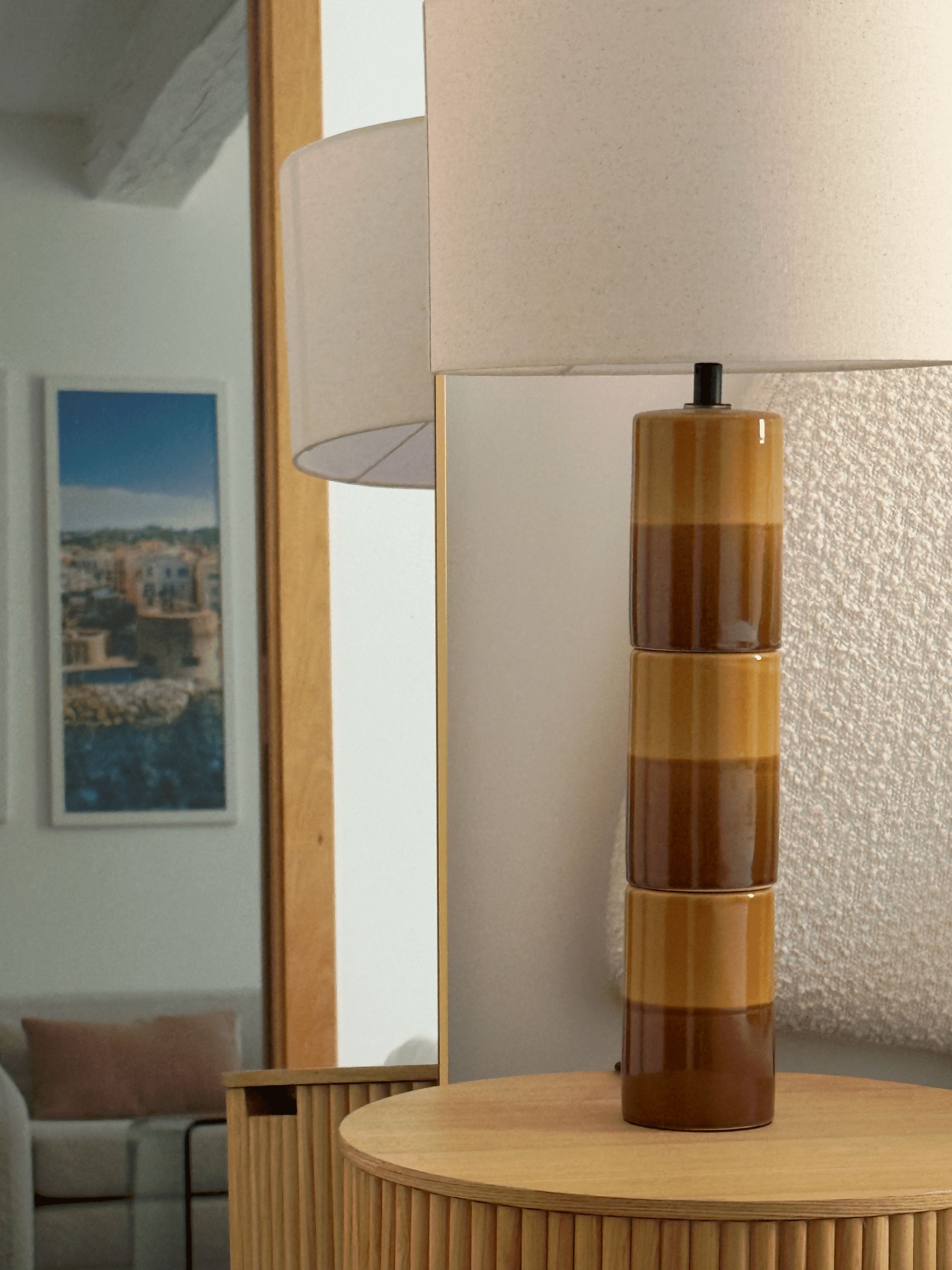 A modern interior with a wooden table and a tall, cylindrical object on it.