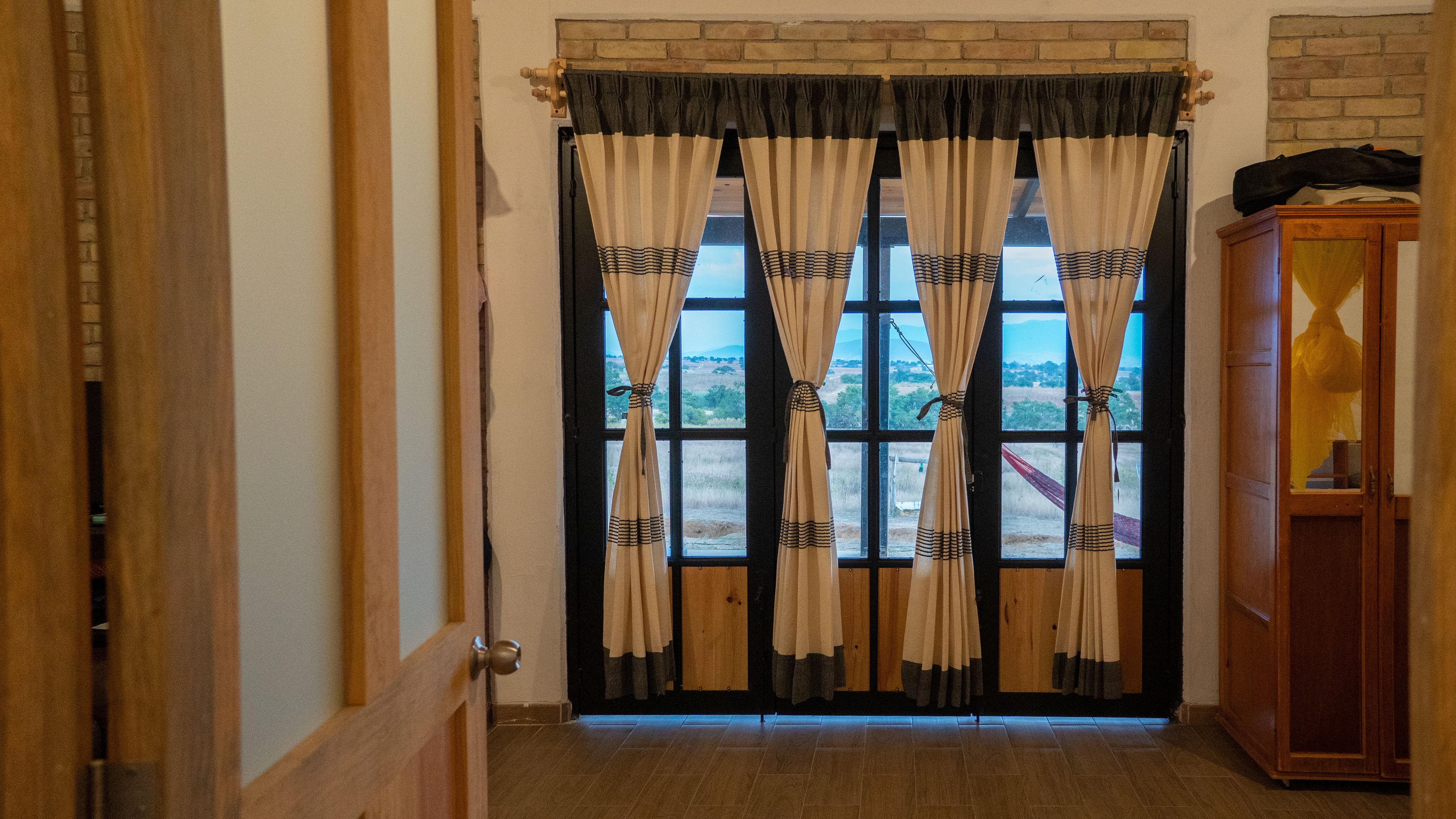 Eine Holztür mit Blick auf eine Landschaft durch ein Fenster.