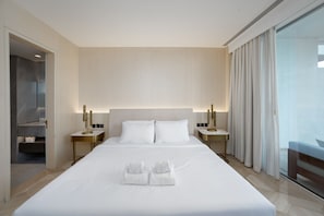 A hotel room with a large bed, two bedside tables, a mirror, and a view of the outdoors. - Modern 2BR Gem Prime Palm Jumeirah Location (Dubai)