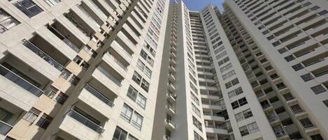 A high-rise residential building with multiple balconies and windows.