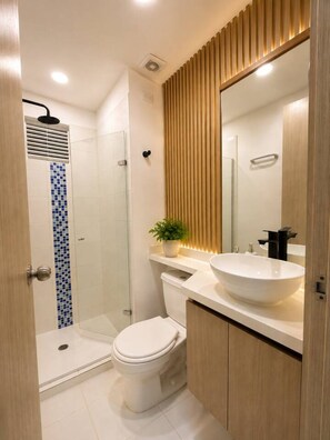 Un bagno moderno con doccia, WC e lavandino.