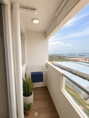A balcony with a view of a coastal area, a drying rack, and potted plants. - Puerto Calma | Work-Life Balance + Pool & Wi-Fi (Cartagena)